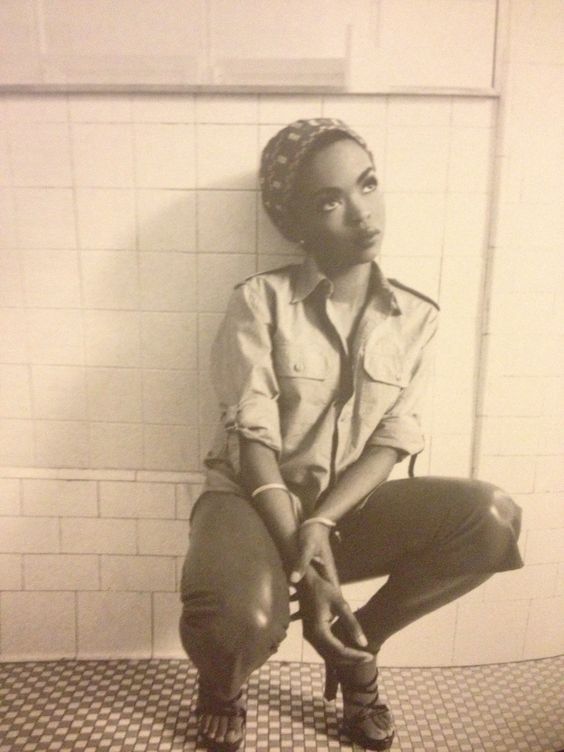 a black and white photo of a woman sitting on a toilet with her legs crossed