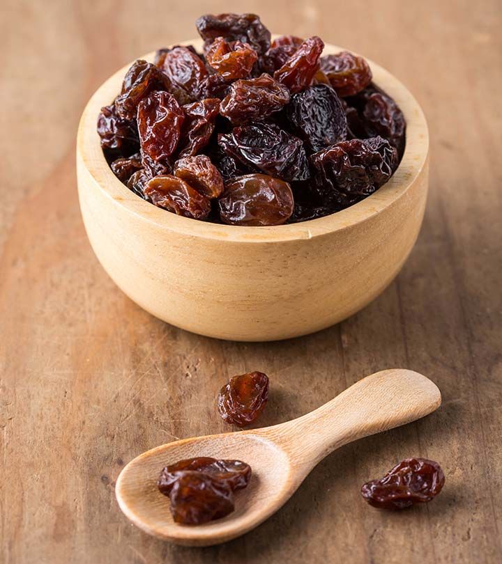 dried raisins in a wooden bowl and spoon