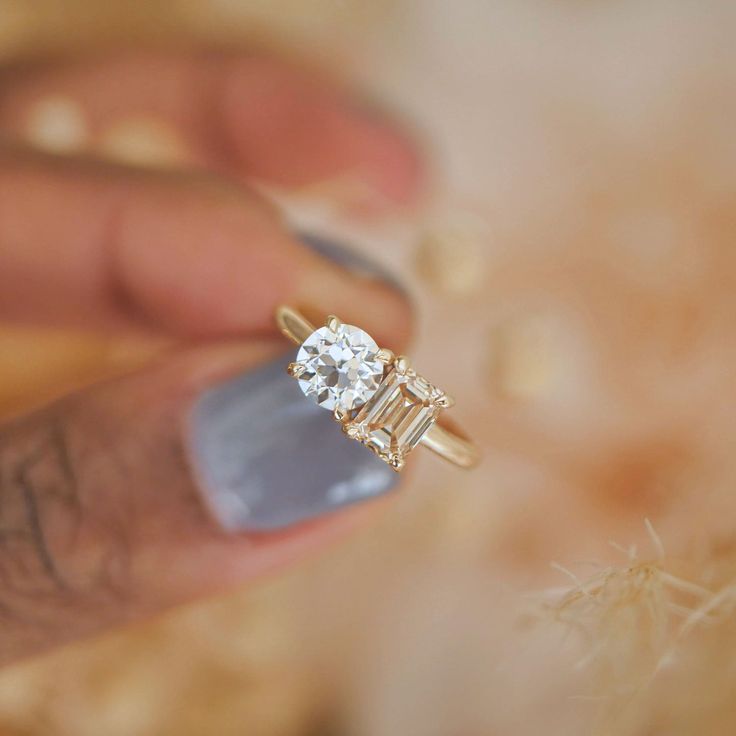 a person holding a diamond ring in their hand