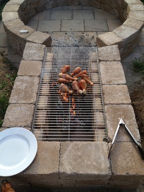 a grill with hot dogs cooking on it