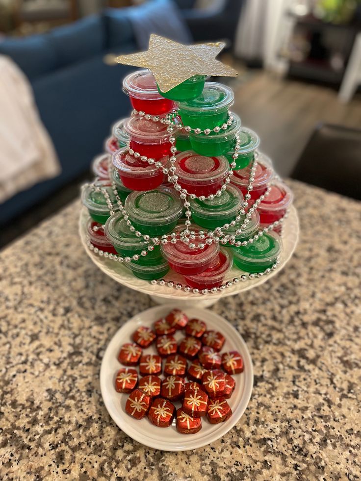 a christmas tree made out of buttons on a counter top with a plate full of candy