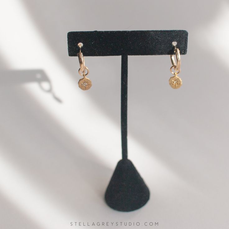 The Oriana gold huggie hoop earrings are a beautiful, delicate addition to anyone's accessory game. The hoops are approx. 15mm and gold filled, suitable for sensitive skin. The charms are approx. 8mm and gold vermeil with a brushed finish, and a stamped star is accented with a tiny CZ stone. 14k gold filled hoops, suitable for sensitive skin Brushed gold vermeil starburst charm Minimalist 14k Gold Filled Huggie Earrings, Dainty Gold Plated Tarnish Resistant Huggie Earrings, Tarnish-resistant 14k Gold Filled Drop Cartilage Earrings, Gold 14k Gold-filled Huggie Earrings, Nickel-free Small Hoop Huggie Earrings In 14k Gold, Tiny 14k Gold Filled Huggie Earrings, Dainty 14k Gold-filled Huggie Cartilage Earrings, Tiny Gold Minimalist Huggie Earrings, Dainty 14k Gold Filled Huggie Cartilage Earrings