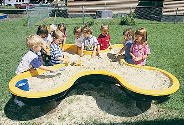 a group of children playing in a sandbox