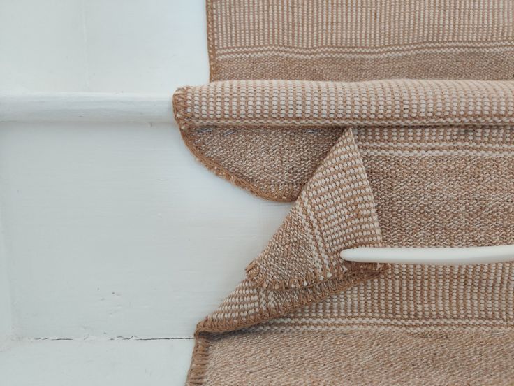 a close up view of a rug on the floor next to a wall with a white handle