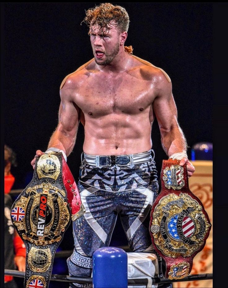 a shirtless man holding two boxing gloves