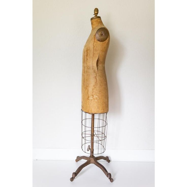 an old wooden mannequin on a metal stand