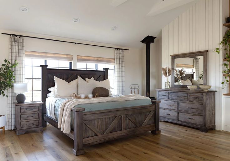 a bedroom with a bed, dressers and mirror in it's center area