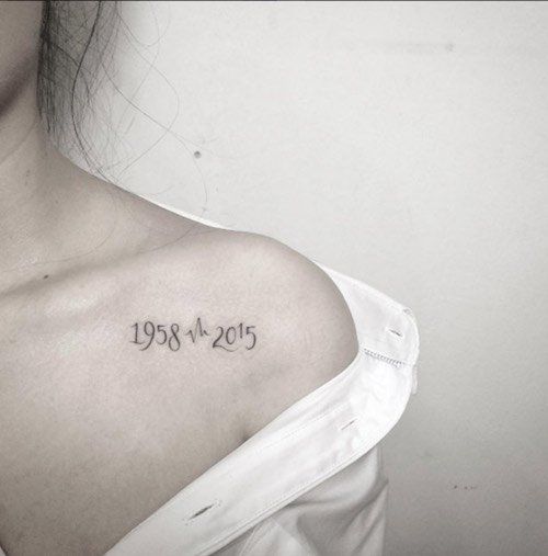 a woman with a tattoo on her shoulder that reads 1932 - 25 and is written in cursive font