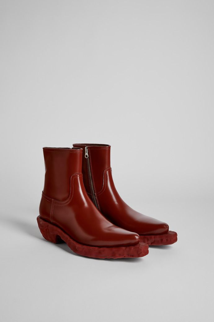 Burgundy leather cowboy-inspired boots. Western Calf Leather Heeled Boots For Fall, Calf Leather Western Heeled Boots For Fall, Western Boots With Sculpted Heel For Fall, Western Moto Boots With Square Toe In Calf Leather, Western Calf Leather Moto Boots With Leather Sole, Western Leather Ankle Platform Boots, Western Style Leather Ankle Platform Boots, Western Style Calf Leather Ankle Moto Boots, Western Calf Leather Chelsea Boots