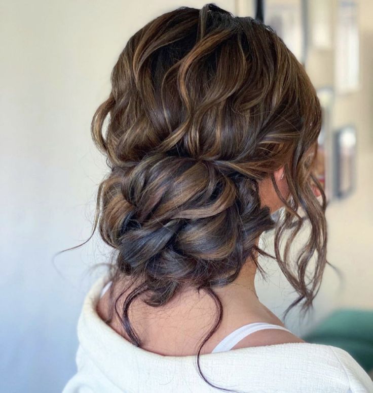 the back of a woman's head, with wavy hair in a low bun