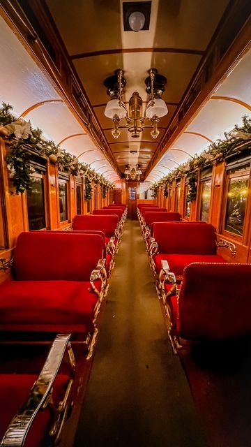 an empty train car with red seats and christmas decorations