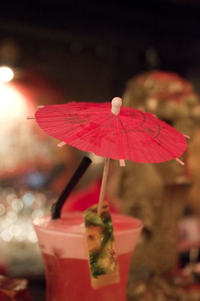 a pink drink with an umbrella on top