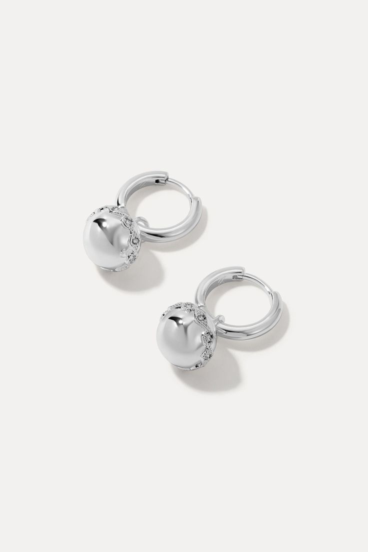 The Aurora Huggies add a touch of sparkle to any look. Featuring carefully selected gemstones and intricate detailing, these huggies catch the light beautifully, creating a radiant glow. Sterling silver-plated brass 20mm drop with a 12mm ball Silver Huggie Earrings With Diamond Accents For Wedding, Elegant Adjustable White Gold Huggie Earrings, Dazzling Silver Round Huggie Earrings, Dazzling Silver Cubic Zirconia Huggie Earrings, Silver Drop Jewelry With Halo Design, Dazzling Silver Huggie Earrings, Silver Huggie Earrings With Sparkling Stones, Dazzling Silver Huggie Earrings For Formal Occasions, Silver Sparkling Stones Huggie Earrings For Gift