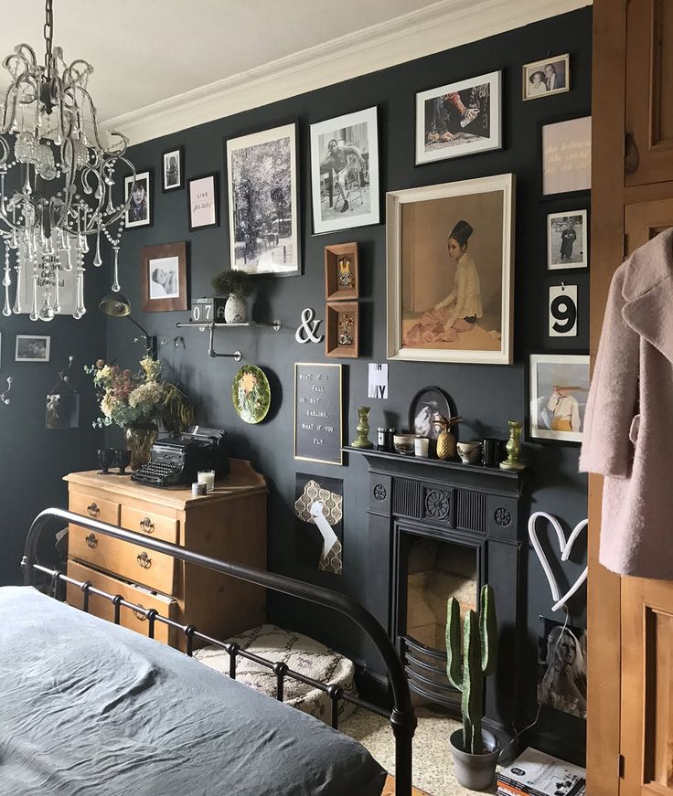 a bedroom with black walls and pictures on the wall