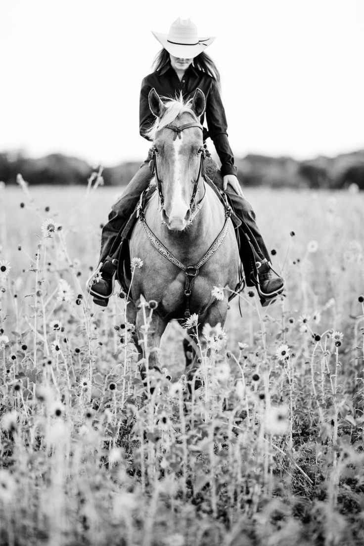 a woman riding on the back of a horse through a field