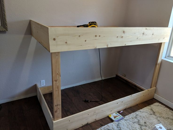 a wooden table with a power cord on top of it next to a window in a room