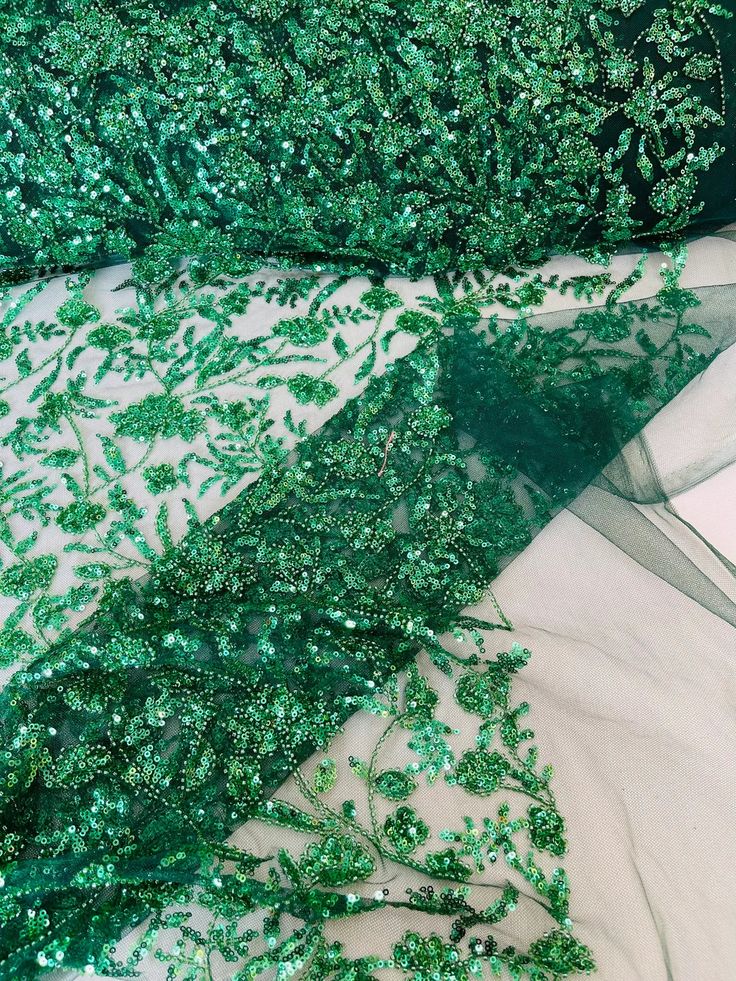 green sequins and mesh fabric with leaves on it