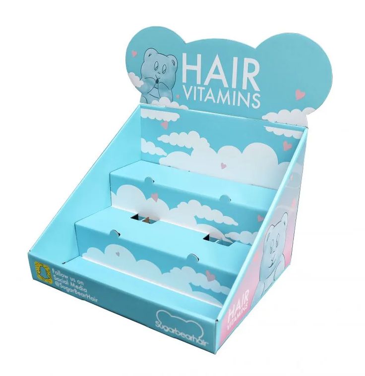 an open cardboard box for hair vitamins on a white background with clouds and teddy bears