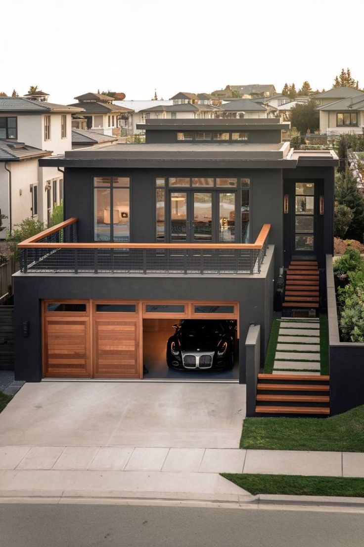 a car is parked in front of a house with stairs leading up to the garage