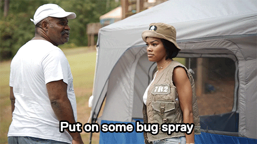 a man standing next to a woman in front of a tent with the caption put on some bug spray