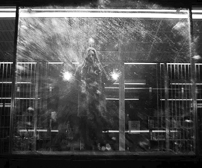 a person standing in front of a window covered in snow and light shining through it