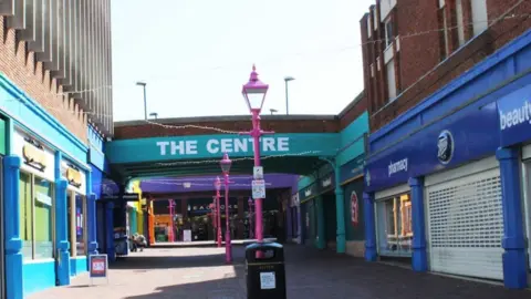 The Centre in Margate, with brightly coloured buildings and pink lampposts viewed on a sunny day.