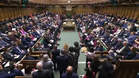 Wide view of a busy House of Commons chamber with MPs debating the assisted dying bill