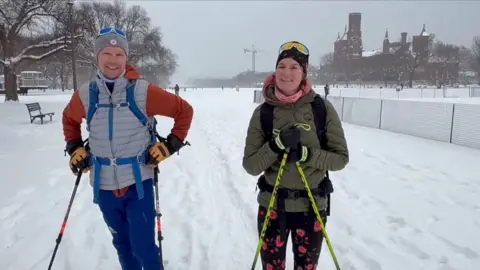 Skiers smile as they stand on the National Mall in Washington DC.