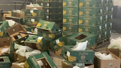 Dozens of emptied banana boxes on the floor of a warehouse