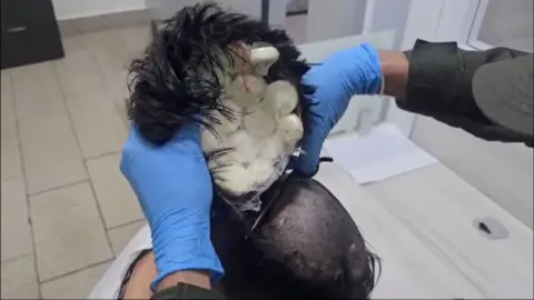 Toupee being cut off head with cocaine inside of it