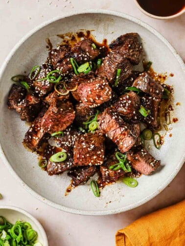 Photo shows thick-cut boneless short ribs cooked in an air fryer with Korean sauce on the side.