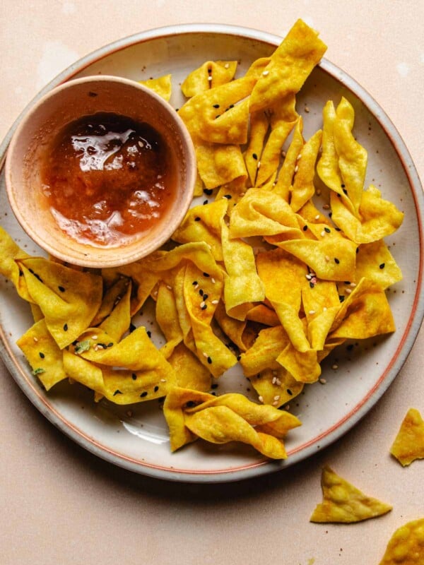 Feature image shows wonton chips made in an air fryer and served with sweet plum dipping sauce on the side.