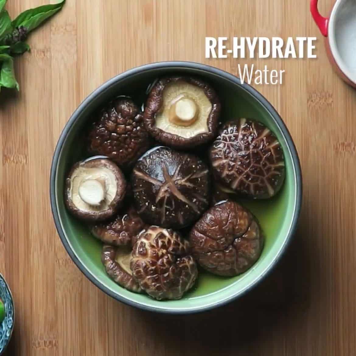 Photo shows a bowl of soaked dried shiitake after rehydrated in a large soaking bowl.