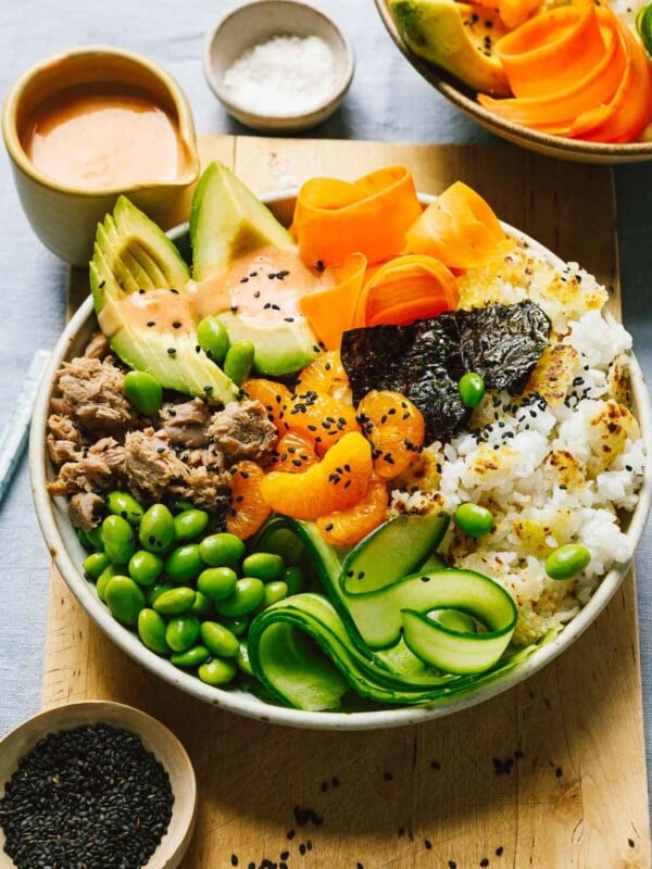 A close shot image shows a bowl of crisp rice with spicy canned tuna and spicy bang bang sauce drizzled over.