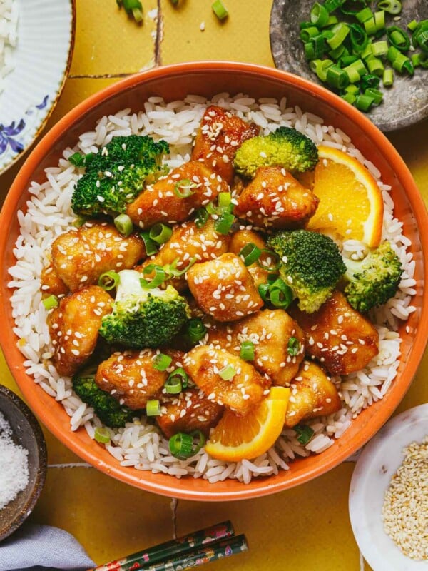 Feature image shows air fryer orange chicken with rice, broccoli, and orange sauce in a bowl.