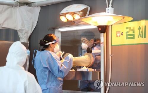 Medical workers prepare for COVID-19 tests at a makeshift test center in Seoul on Dec. 19, 2020. South Korea has been witnessing another wave of the new coronavirus, with daily cases hovering above 1,000 for four straight days. (Yonhap)