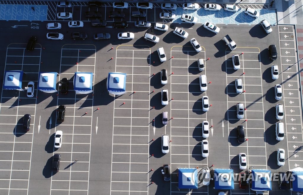 Drivers wait in lines to receive drive-thru COVID-19 tests at a makeshift clinic in Gangneung, 237 kilometers south of Seoul, on Dec. 15, 2020. (Yonhap)