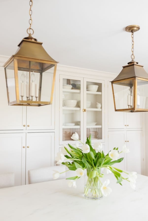 Two brass lantern pendants hanging over a kitchen island