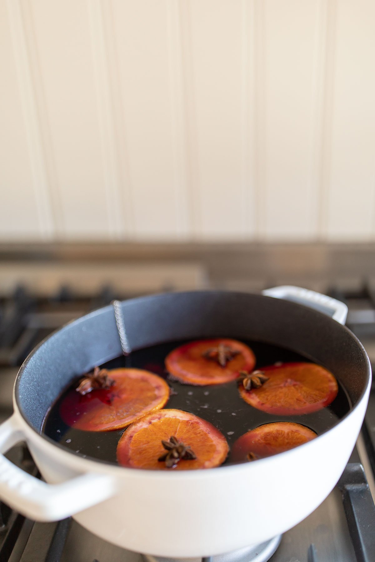 Mulled wine in a cast iron pot on a stovetop.