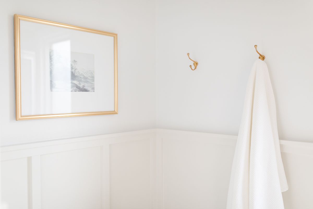 A bathroom with two different paint colors and paint sheens between the board and batten and drywall above.