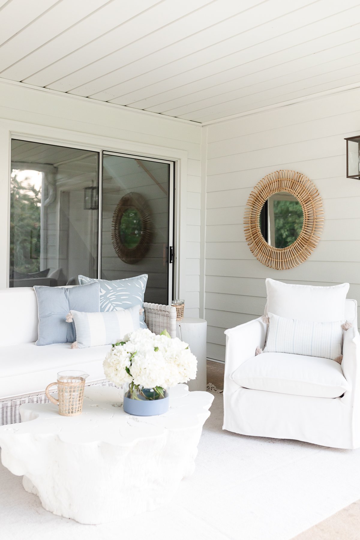 A white living room with wicker sofa and a white coffee table.