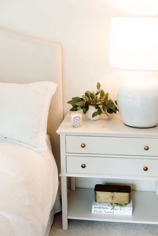 A primary bedroom with white bedding and simple nightstand decorating