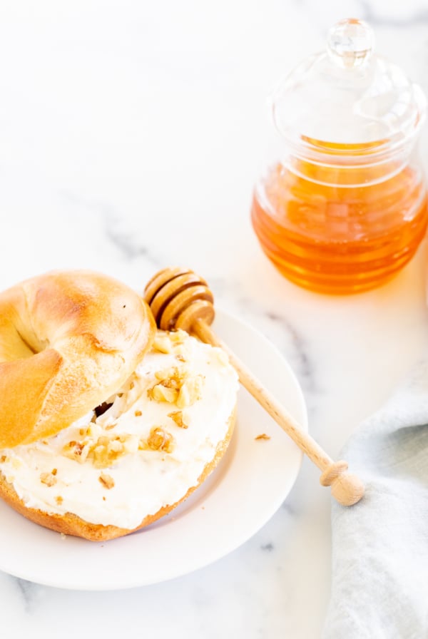 A bagel with honey walnut cream cheese on a plate.