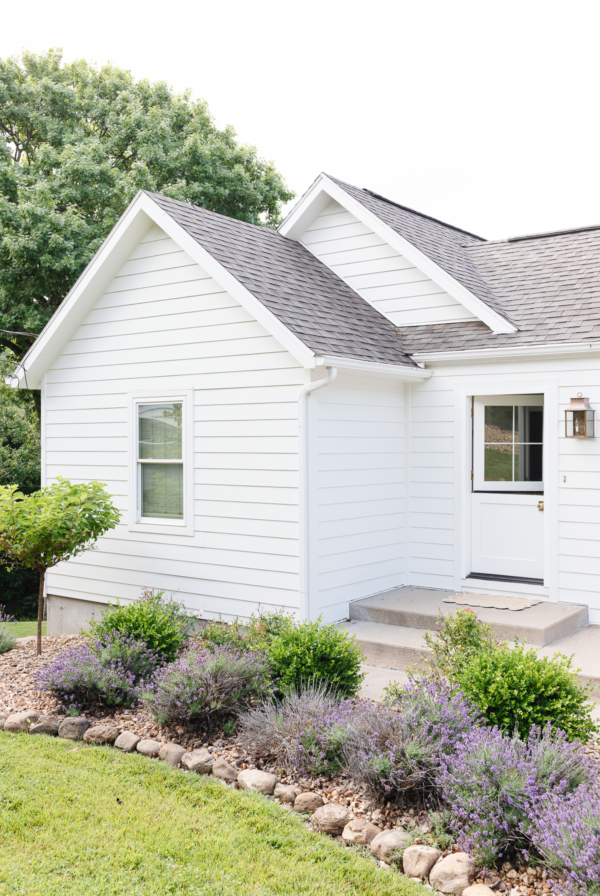 A home with a white exterior and purple landscaping.