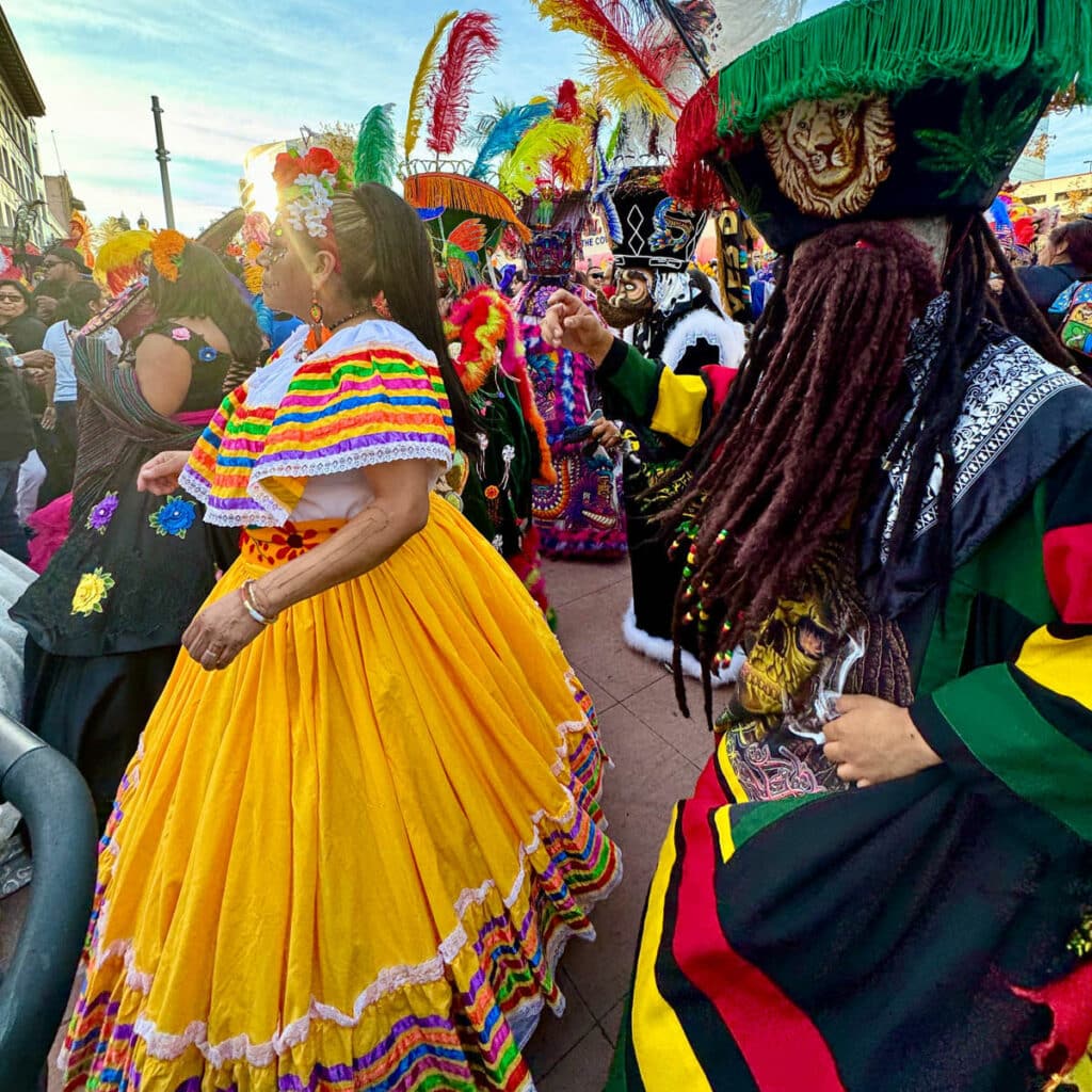 Woman and others in festive dress dancing at a street party.