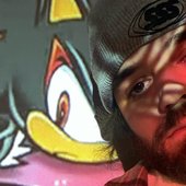 Madeon staring towards the camera in front of a projection of Shadow The Hedgehog from the Sonic Adventure 2 cover artwork