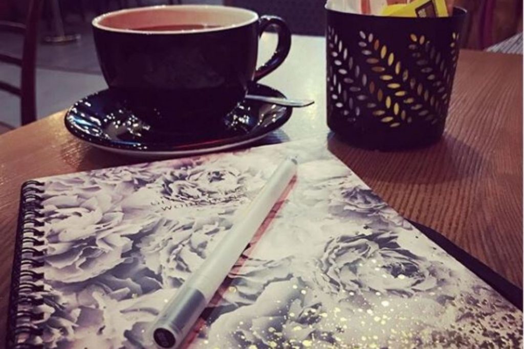 essential writing tools: a notepad, a pen and coffee