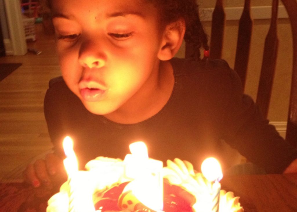 Rebecca blows out the candles on a birthday cake.