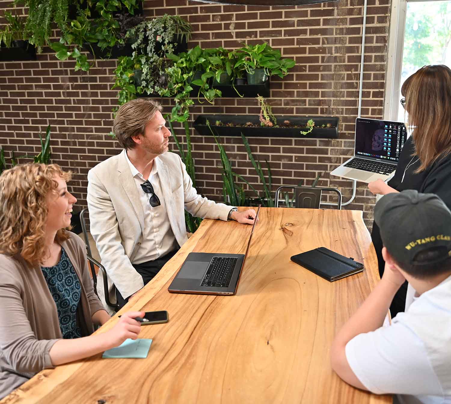 Team meeting in modern office with brick wall