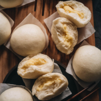 Chinese Steamed Custard Buns (nai wong bao, 奶黄包) | A dim sum classic, these buns are perfect for holiday gatherings and parties as well. Made with a yeast dough and steamed, the buns have a super soft and spongy texture with a smooth surface. The custard filling is creamy, fragrant, and sweet. The recipe includes detailed step-by-step pictures to help you recreate the restaurant-style custard buns in your own kitchen.